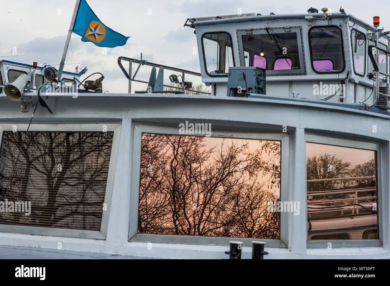 Winter Zweige in der Gold wider - getöntes Fenster von einem Boot in Berlin, Deutschland. Stockfoto