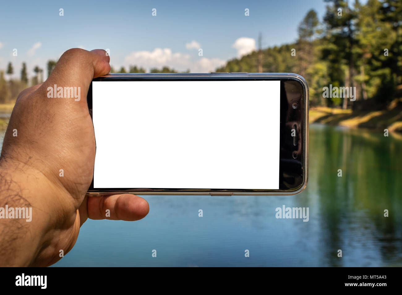 Eine Person, die ein Smartphone in der Hand, mit einem leeren Bildschirm des Smartphones Stockfoto