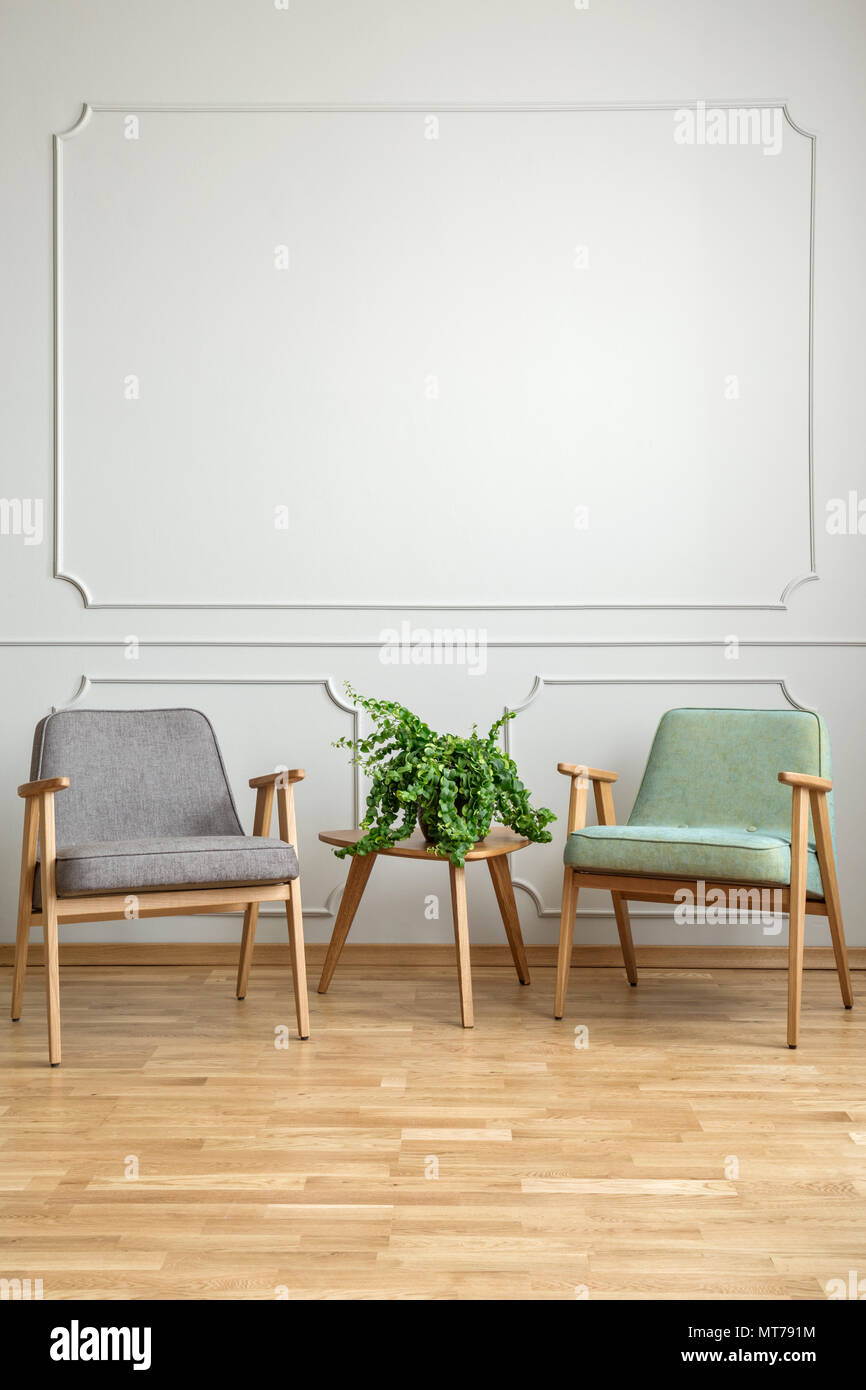 Anlage auf hölzernen Tisch zwischen Sesseln in minimalen Wohnzimmer Interieur mit kopieren. Real Photo Stockfoto