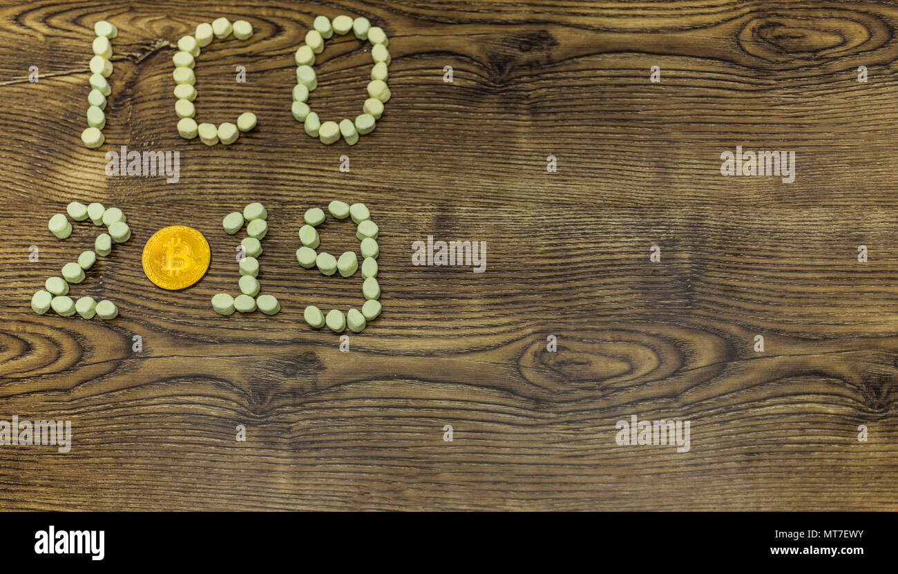 Golden bitcoin und Marshmallows bilden ICO 2019 text auf Holz. Stockfoto