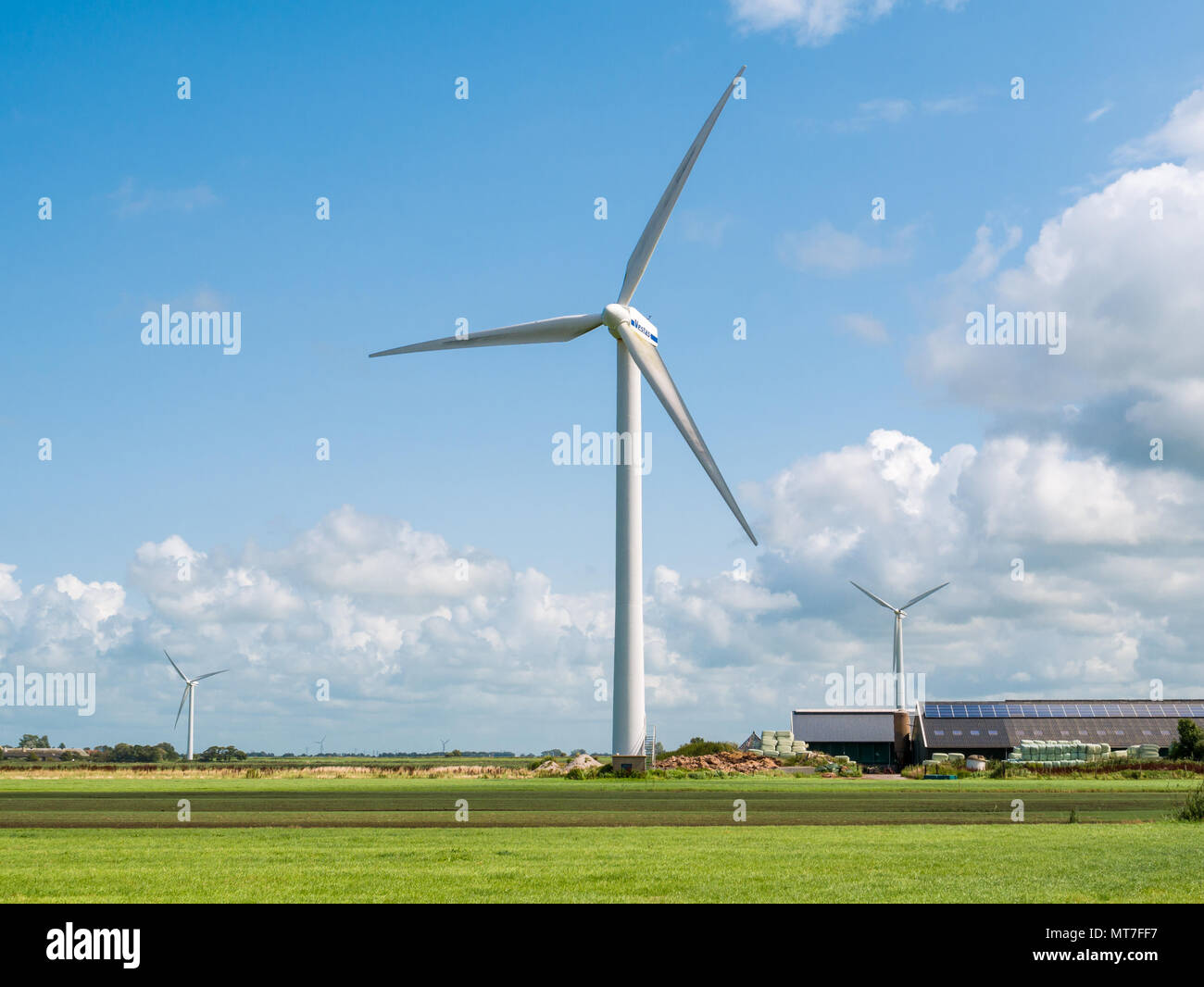 Bauernhof mit Solarzellen und Wind Generator im Polder in der Nähe von Makkum, Friesland, Niederlande Stockfoto