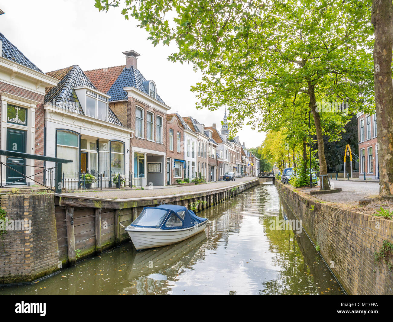 Kanal mit Bäumen, Boot und historischen Häuser in der Altstadt von Bolsward, Friesland, Niederlande Stockfoto