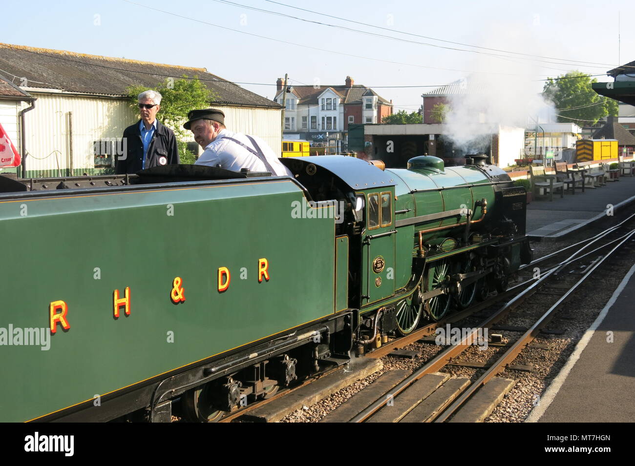 Freiwillige und Fahrer an der Romney, Hythe & Dymchurch Railway steht neben der Lokomotive Typhoon in New Romney Station, Kent Stockfoto