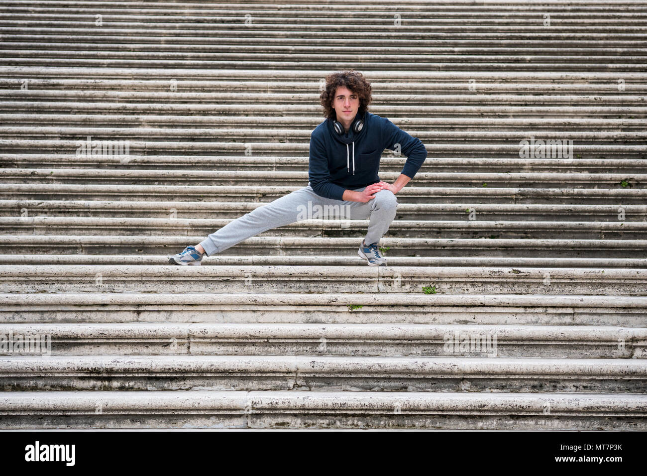 Hübscher junger Sportler dehnen und Aufwärmen für das Training auf Treppe Stockfoto