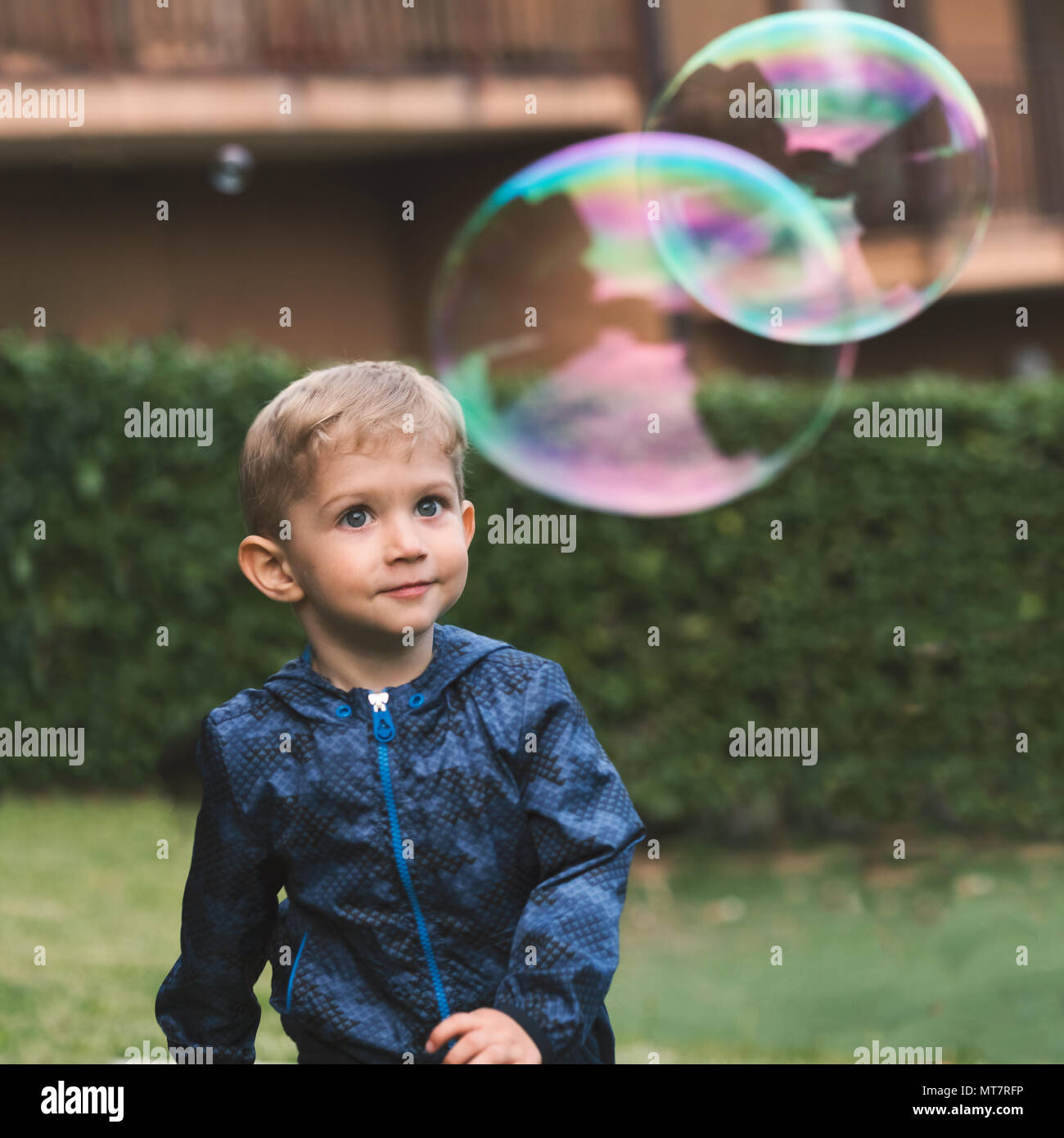 Schönes baby boy genießend Blasen grosse Seifenblasen im Herbst. Glückliche Kindheit Konzept. Stockfoto
