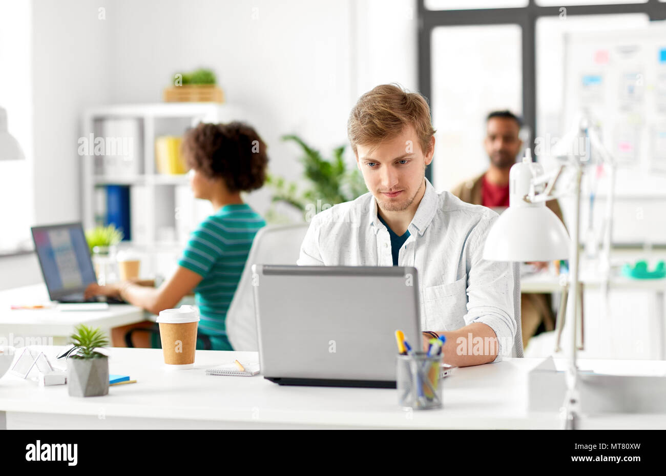 Kreative männliche Mitarbeiter mit Laptop Stockfoto