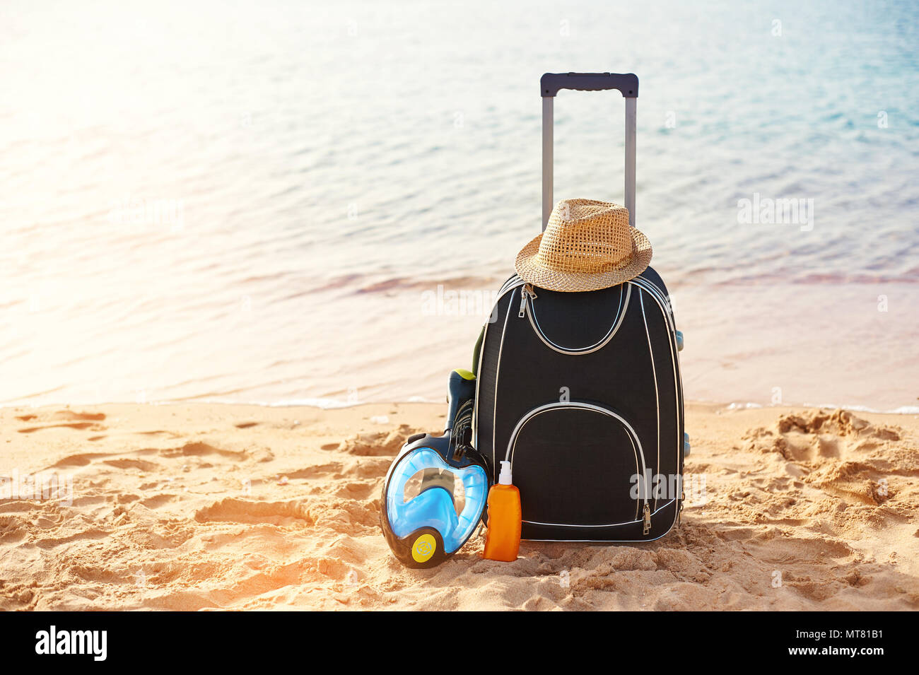 Koffer und Hut, Sonnencreme mit einer Maske. Das tropische Meer, Strand, im Hintergrund. Das Konzept der Sommer World Deutsch Freizeit Reisen und Verkehr Stockfoto Koffer und Hut, Sonnencreme mit einer Maske. Das tropische Meer, Strand, im Hintergrund. Das Konzept der Sommer World Deutsch Freizeit Reisen und Verkehr Stockfoto
