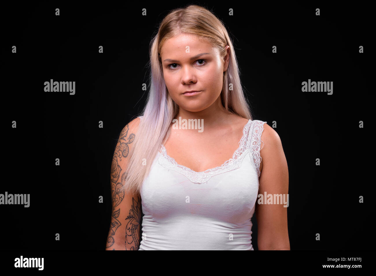 Junge hübsche blonde Frau auf schwarzem Hintergrund Stockfoto