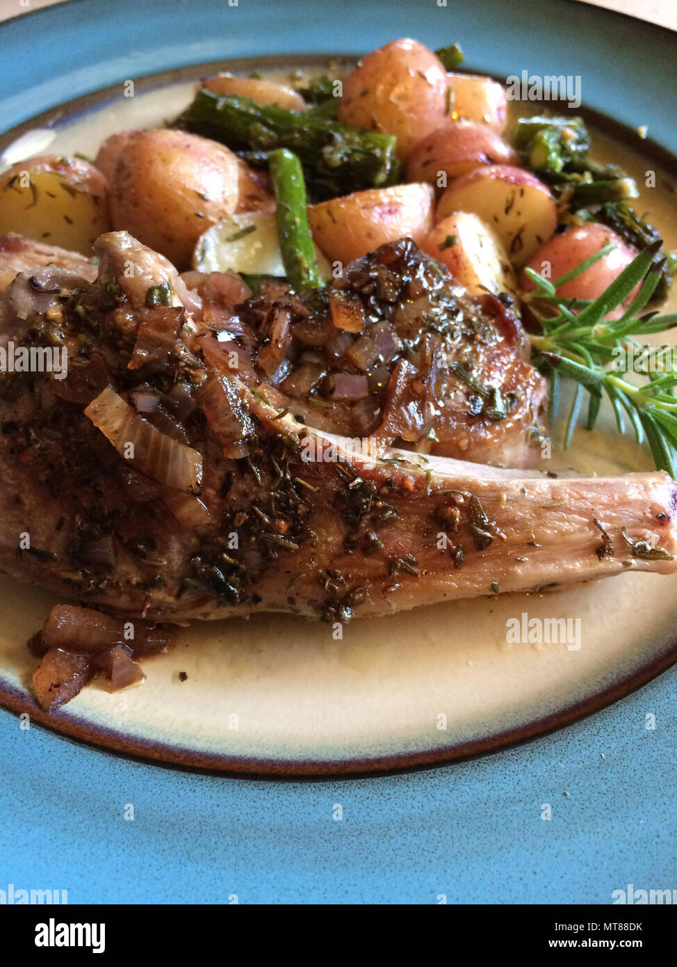 Lammkotelett Essen mit roten Kartoffeln, Spargel und Rosmarin Stockfoto