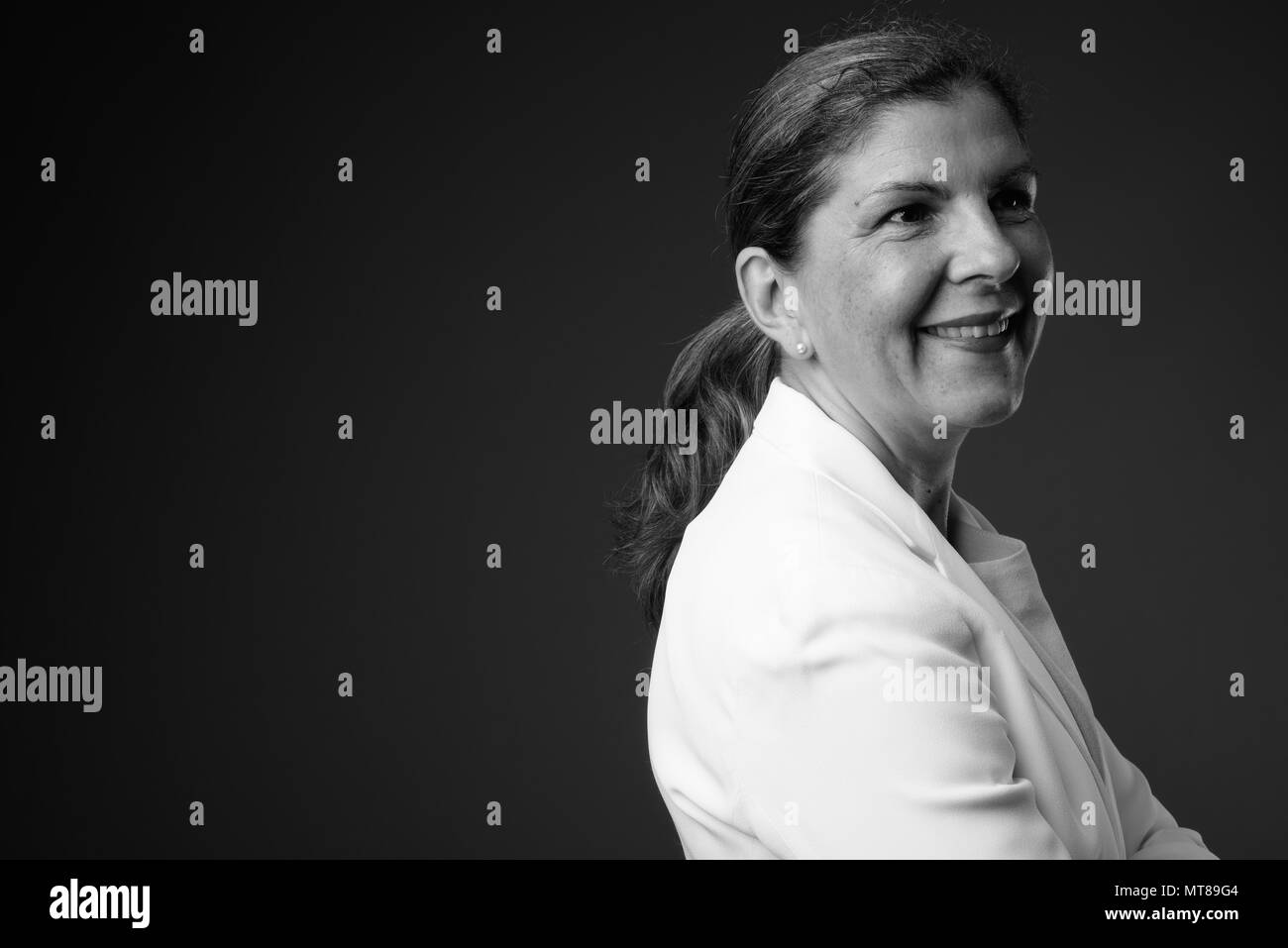 Reifen schöne Geschäftsfrau gegen grauen Hintergrund in Schwarz Stockfoto