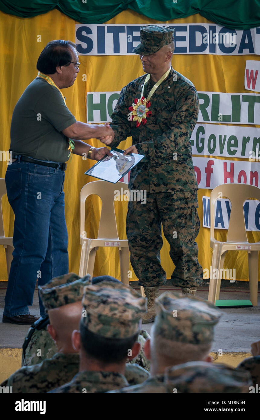 Us Marine Corps Oberstleutnant Soulynamma Pharathikoune, rechts, erhält ein Zertifikat, das von der stellvertretende Gouverneur von Tarlac Enrique Cojuangco, Jr. während einer Feierstunde an Calangitan Grundschule zur Unterstützung der Übung Balikatan in Capas, Tarlac, Philippinen, 16. Mai 2018. Pharathikoune ist die Co - Kommandeur der Combined Joint Task Force zivil-militärische Operationen und der kommandierende Offizier des 9. Techniker Bataillon, 3. Marine Logistics Group. Übung Balikatan, in seiner 34. Iteration, ist eine jährliche US-Philippinischen militärische Ausbildung Übung konzentriert sich auf eine Vielzahl von Missionen, die inclu Stockfoto