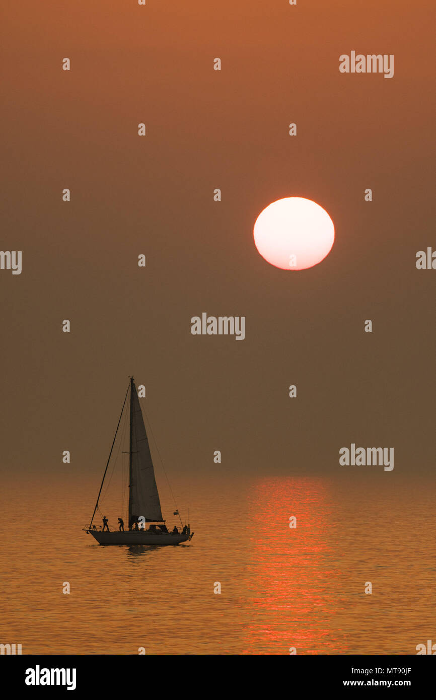Aberystwyth Wales UK Bank Holiday Montag, 28. Mai 2018 UK Wetter: Die Bank Holiday Montag kommt zu einem Ende mit einem spektakulären orange Sonnenuntergang über einer Yacht schwimmt auf dem ruhigen Wasser der Cardigan Bay, direkt an der Strand in Aberystwyth an der Westküste von Wales Foto © Keith Morris/Alamy leben Nachrichten Stockfoto