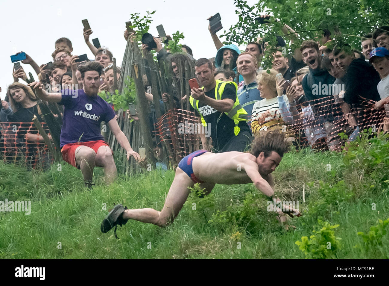 Gloucester, Großbritannien. 28. Mai 2018. Jährliche Cheese Roll auf Coopers Hill. Zurückgehend bis 1800, die jährliche Cheese-Rolling und Rennen mit fearless Konkurrenten auf der Jagd nach einem 9 lb (4.1KG) runde Double Gloucester cheese 200 Meter die 1: 2 Steigung Hill. Der Käse ist einer Sekunde Vorsprung und kann Geschwindigkeiten bis zu 70 mph erlaubt. In der Regel gibt es eine Reihe von Verletzungen pro Jahr. Credit: Guy Corbishley/Alamy leben Nachrichten Stockfoto