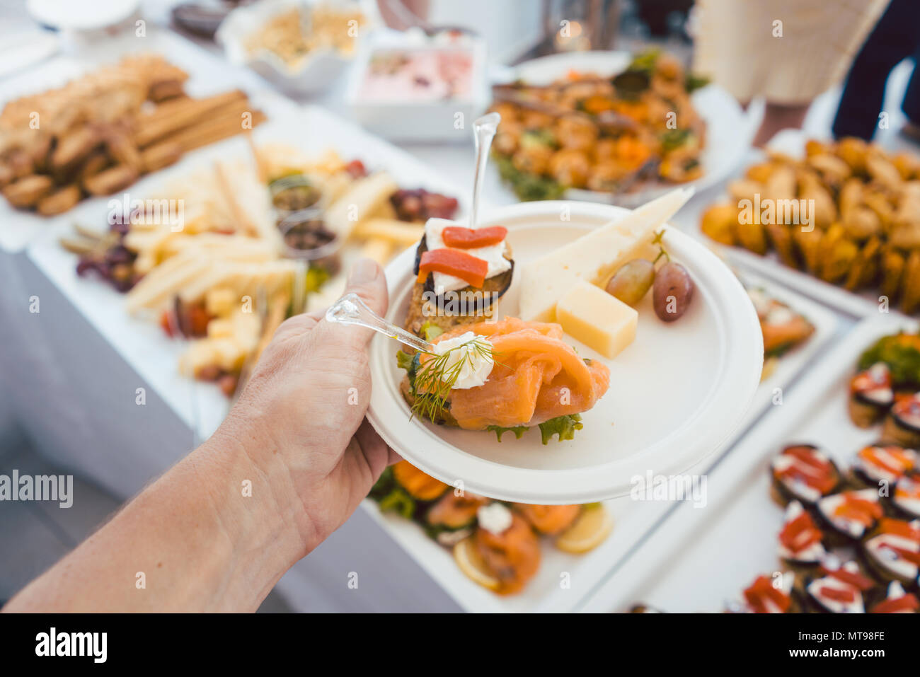Man hilft sich selbst am Buffet der Party im Freien essen Stockfoto