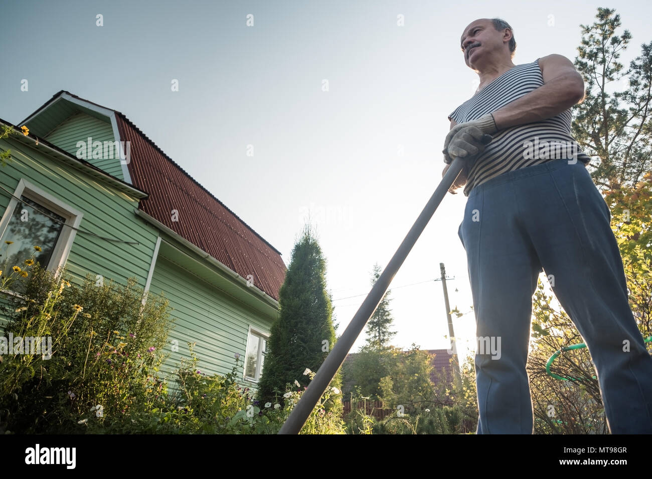 Reifen Mann in seinem Garten und Ausruhen nach graben den Boden. Stockfoto