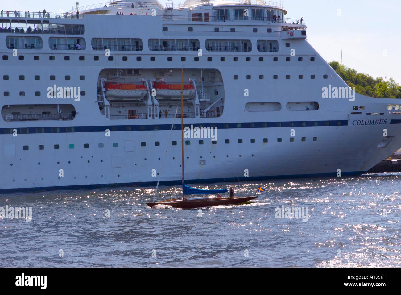 Die Viking Line Cruise Schiff neben einer kleinen hölzernen Segelboot mit einem schwedischen Flagge auf der Ostsee in Stockholm, Schweden Stockfoto