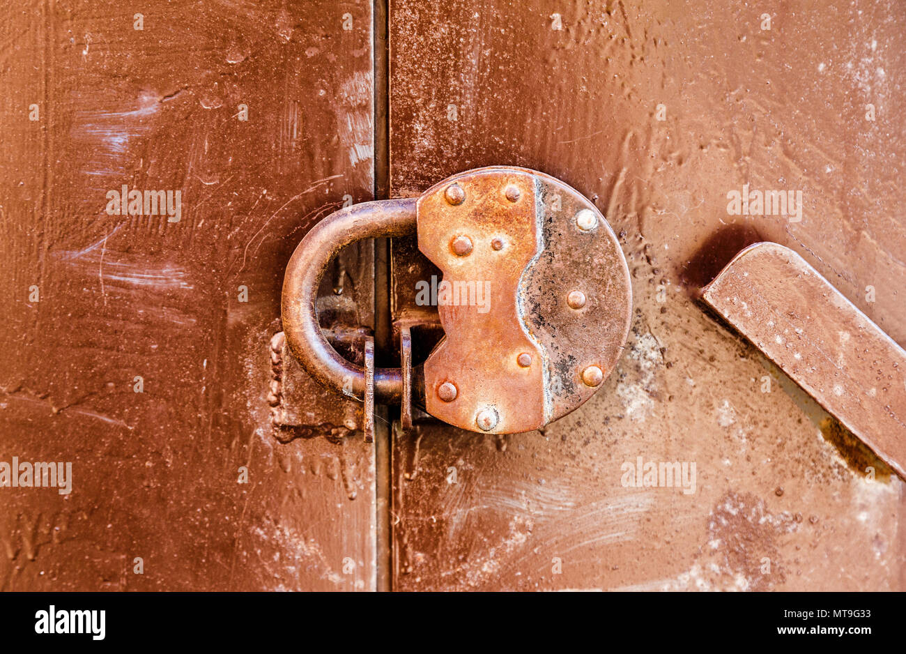 Rostige Vorhängeschloss an einem alten Metalltür Stockfoto