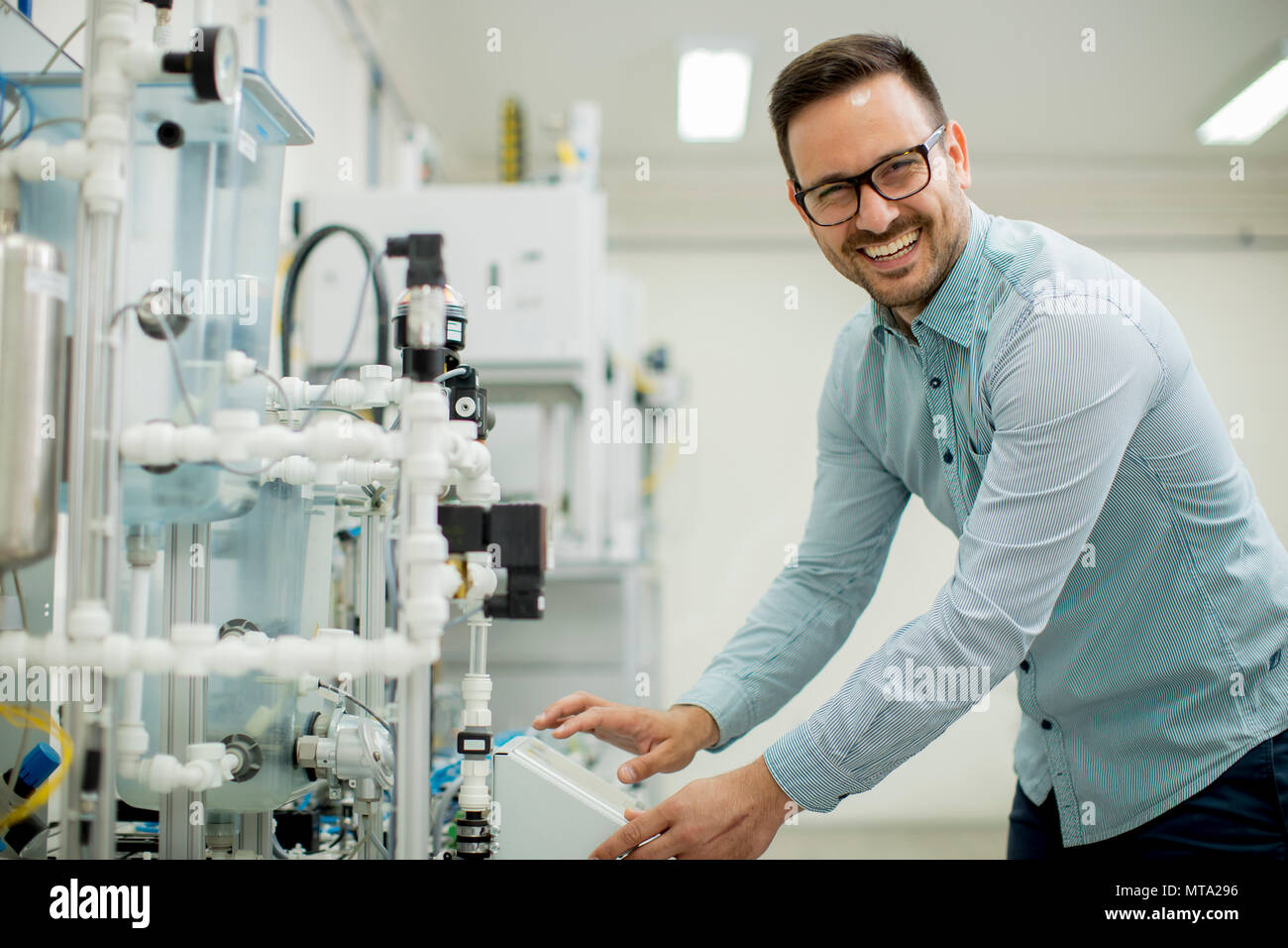 Hübscher junger Mann, der in der elektronischen Werkstatt Stockfoto
