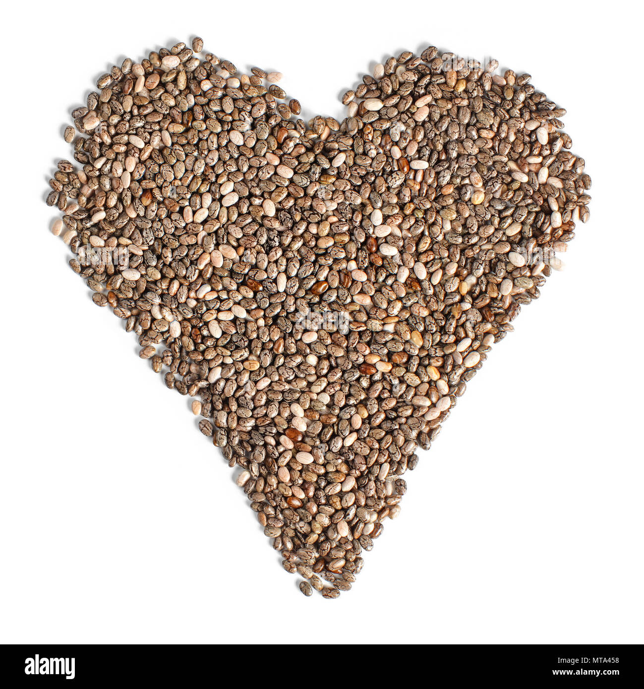 Draufsicht auf Chia (Salvia hispanica) Samen in Form von Herzen angeordnet, auf weißem Hintergrund. Essen für ein gesundes Herz-Kreislauf-System Konzept. Stockfoto