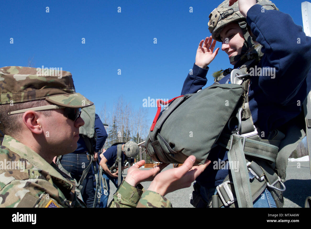 Armee 1. Lt Matthew Sneddon, 1.BATAILLON, 501 Fallschirm Infanterie Regiment Air Officer und native von Fayetteville, N.C., inspiziert Eagle River High school Luftwaffe Junior ROTC Kadett Riley Sheldon vor der High School Student springt von einer 34-Fuß springen Turm April 19, 2017, auf der gemeinsamen Basis Elmendorf-Richardson Airborne Sustainment Training Bereich. Viele der gleichen Sicherheitsüberprüfungen für eine tatsächliche Fallschirm gesprungen sind für springen Turm Schulung verwendet. Sheldon ist die Tochter von Sgt. Maj. Ronald Sheldon, der 673 d Air Base Wing Sergeant Major. Stockfoto