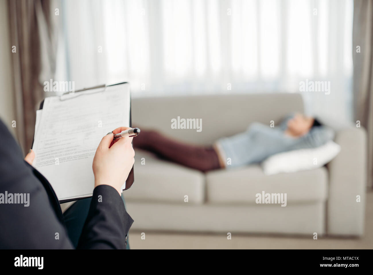 Weibliche Patient liegt auf Sofa bei psychotherapeut Rezeption. Ärztin schreibt Notizen in Notepad, professionelle Psychologie Unterstützung Stockfoto