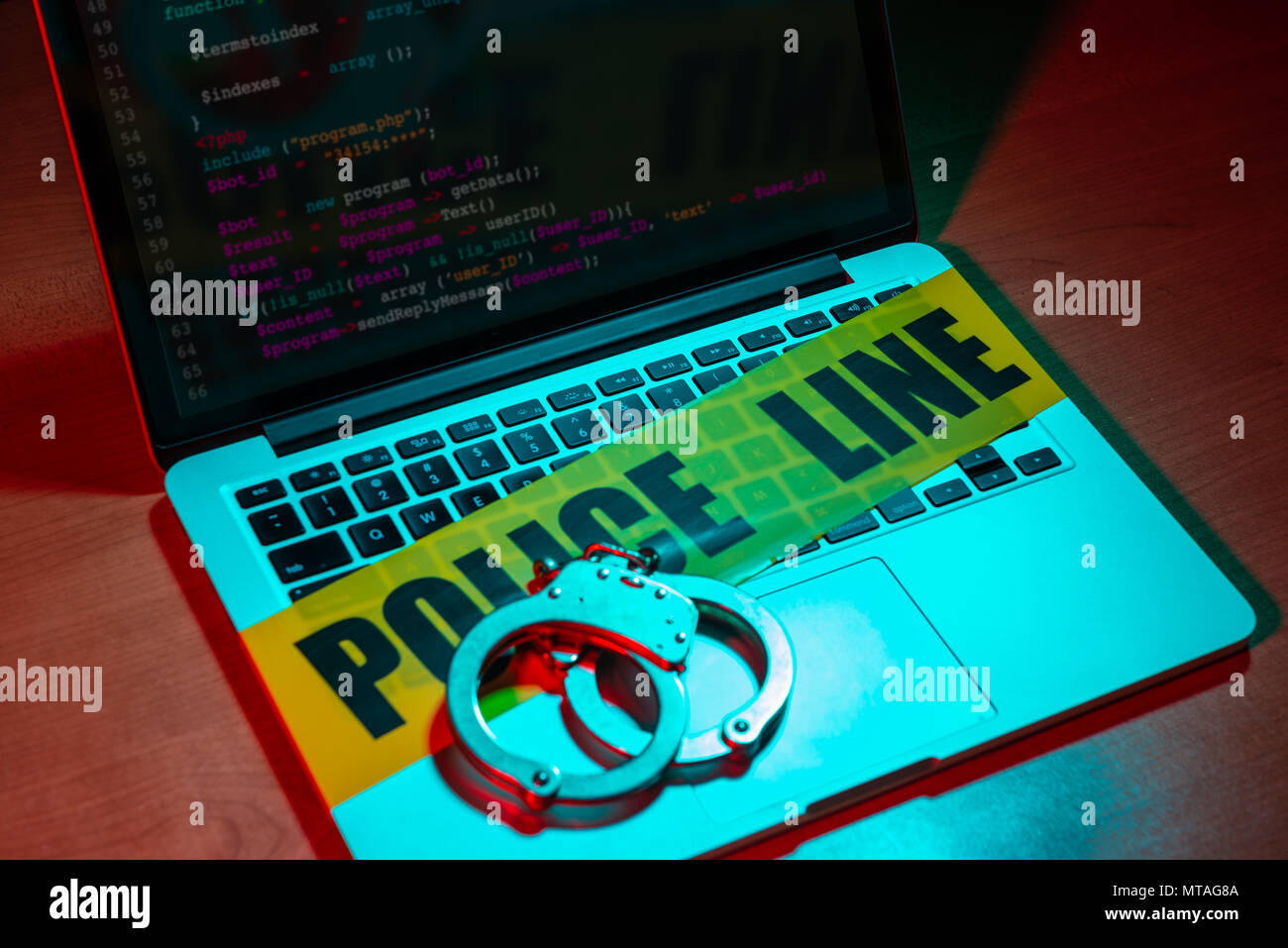 Ein paar Handschellen und Polizei Kassetten sich auf einem Laptop Tastatur. Technologie/Internetkriminalität Konzept. Stockfoto