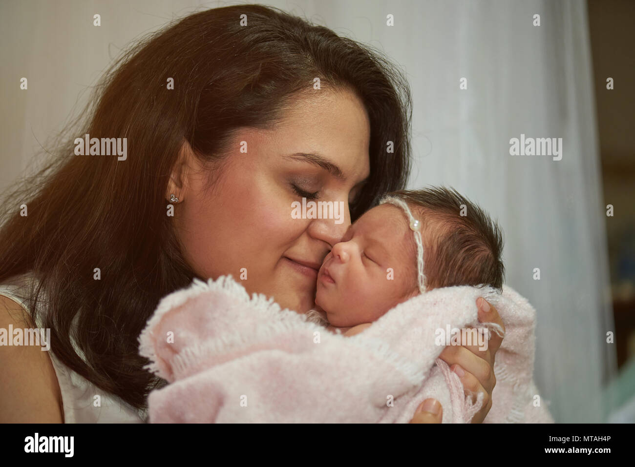 Latina Mutter umarmt neugeborenes Baby Nähe zu sehen. Stockfoto