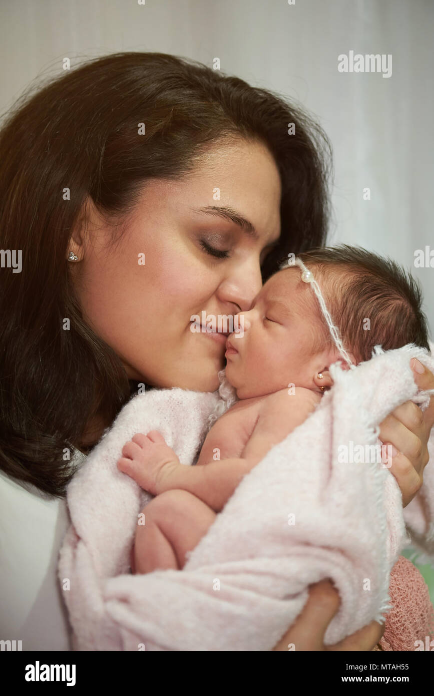 Hispanic Mutter halten neugeborenes Kind mit geschlossenen Augen Stockfoto