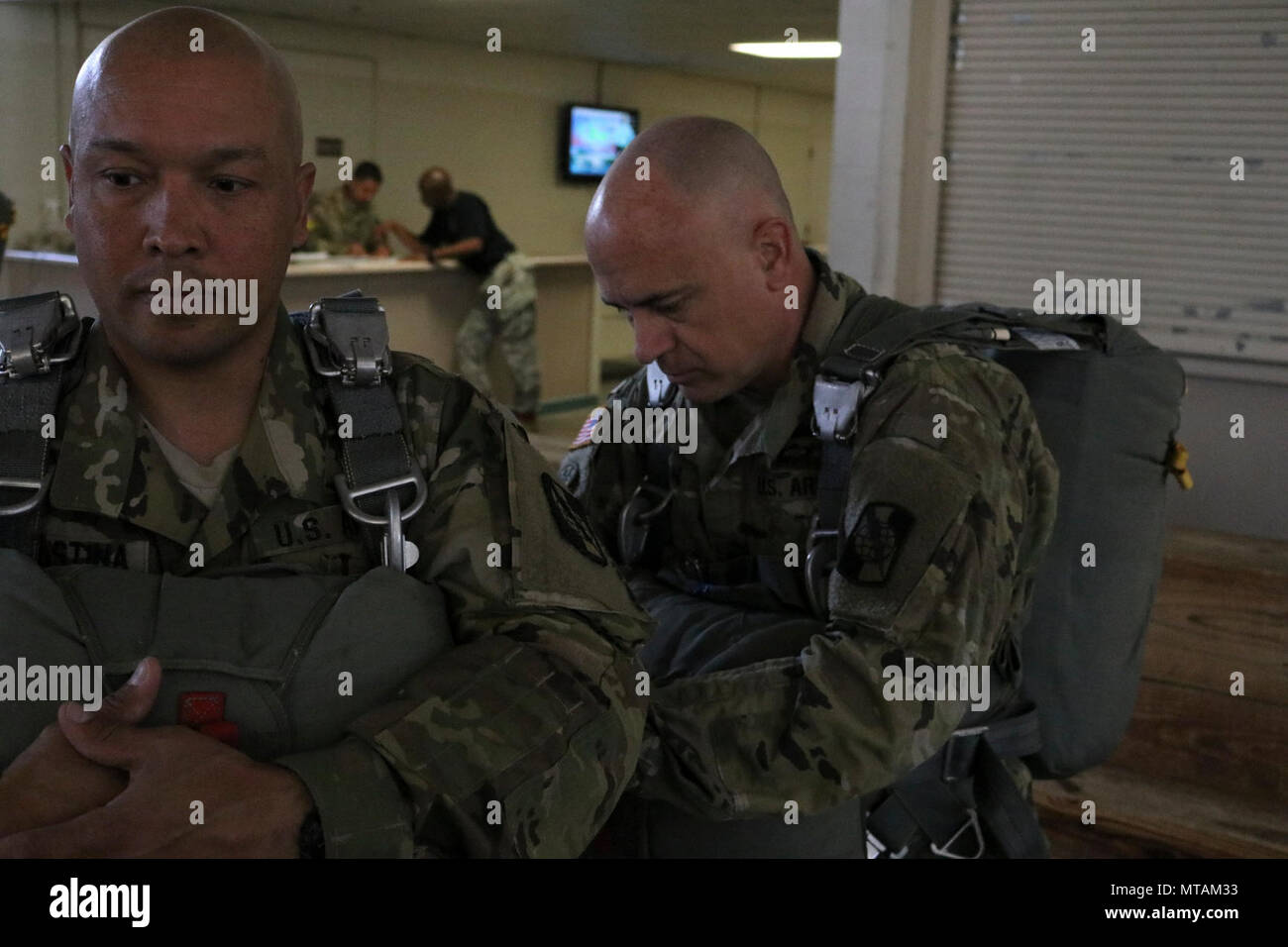 U.S. Army CPT. Loren Teillon, Recht, Kommandant der 982nd Combat Camera Company, prüft ein Fallschirm-Geschirr, US Army Spc. Rafael DiCristina, links, auch zugewiesen, um die 982nd Combat Camera Company angehören, während Fallschirm Ausbildung Operationen an Papst Army Airfield befindet sich in Fort Bragg, NC, 21. April 2017. US-Soldaten, die 982nd Combat Camera Company, 824th Quartermaster Company und der United States Army Civil Affairs und Psychological Operations Command zugewiesen bereiteten für einen Fallschirmsprung aus einem c-130 Hercules Flugzeuge auf Sizilien-Drop-Zone befindet sich in Fort B Stockfoto