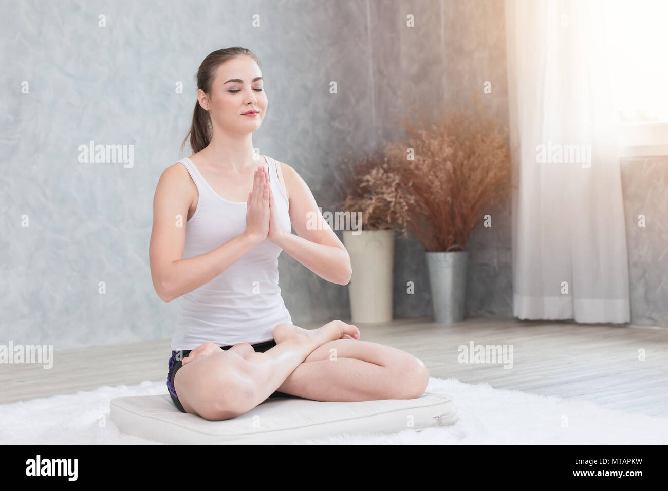 Yoga Meditation zu Hause. Gesunde weibliche sitzen Konzentration die Hände auf der Brust des Friedens in Seele und Geist Konzept Stockfoto