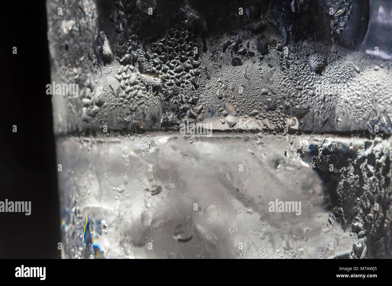 Eisige Wasser in einem Glas Schale. Glas mit Eiswasser und Eiswürfel. Abkühlung an einem heißen Tag Konzept. Stockfoto