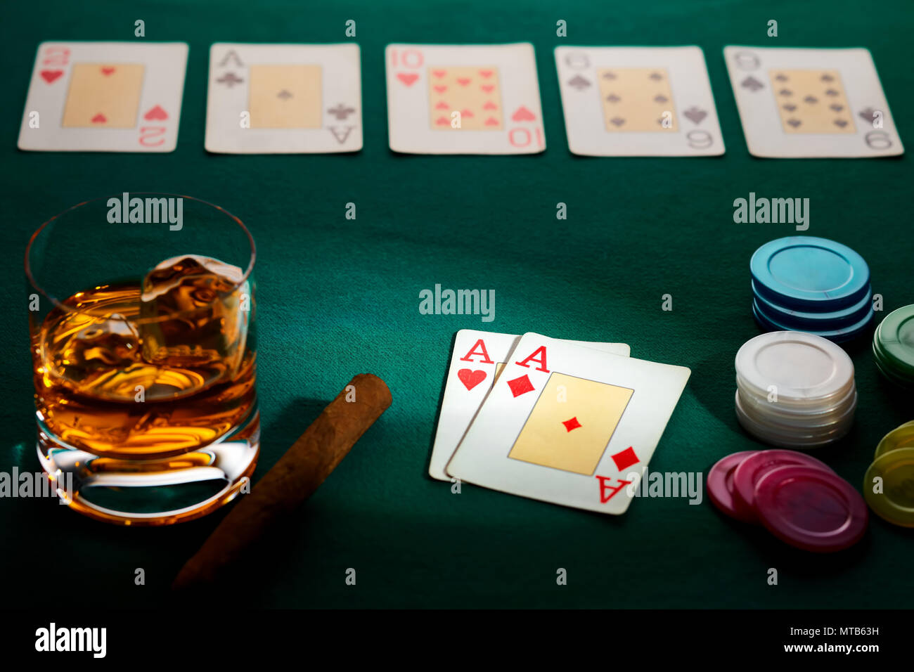 Texas Hold'em Poker mit einer Hand von zwei Asse, Chips, Zigarre, und Glas Whiskey auf Grün glänzende Baumwollstoff. Gewann durch drei Asse. Stockfoto