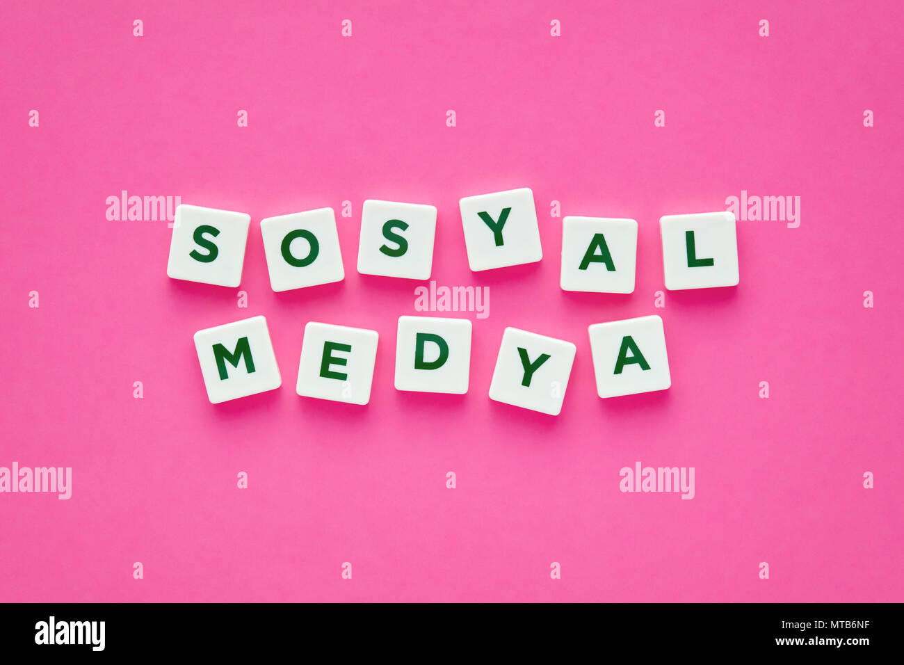 Social media Wörter auf Türkisch mit grünen Buchstaben auf weißem Quadrat Tasten auf rosa Hintergrund. Konzept für On-line-dating. Stockfoto