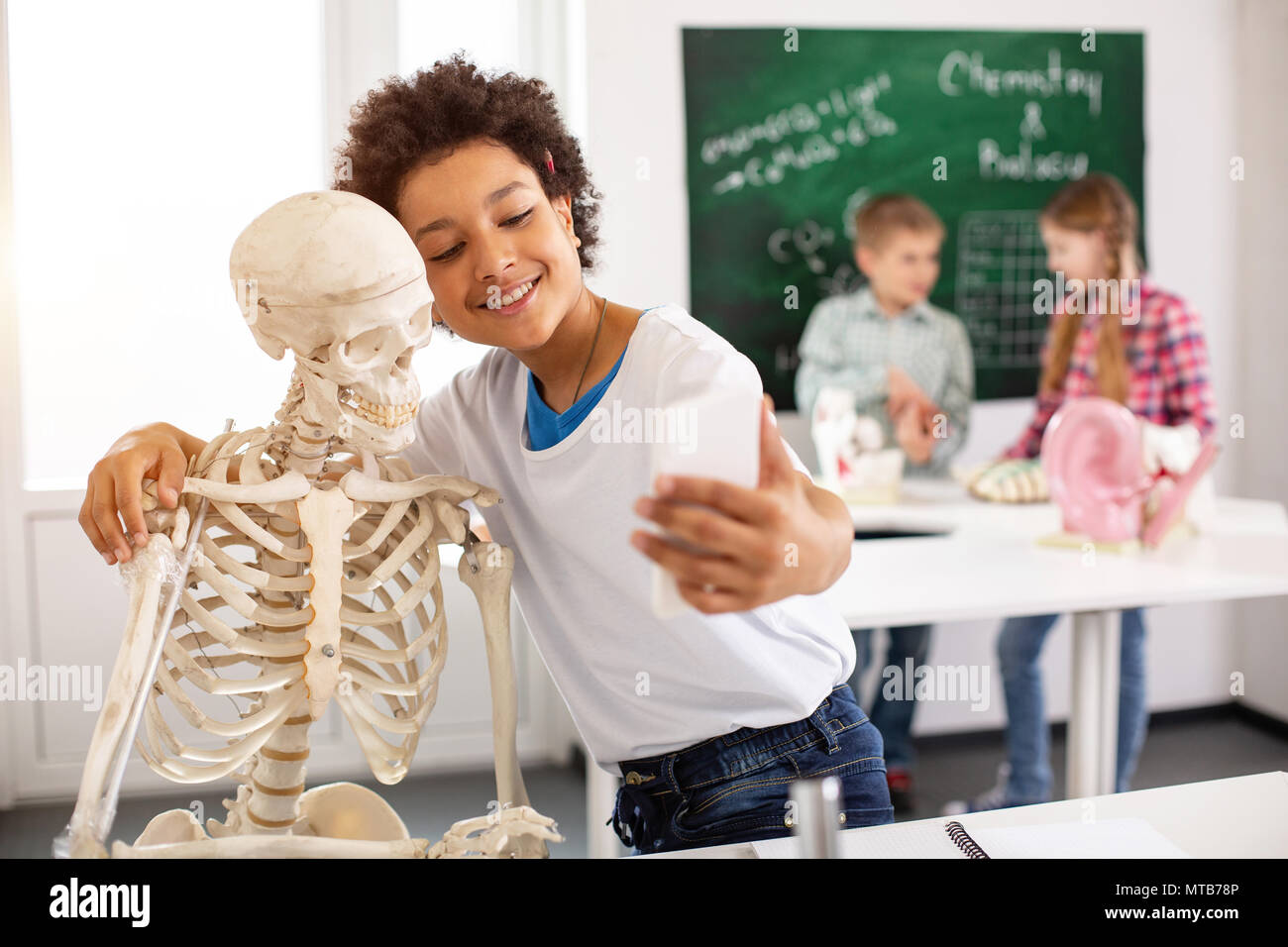 Nette freundliche junge umarmen ein Skelett Stockfoto
