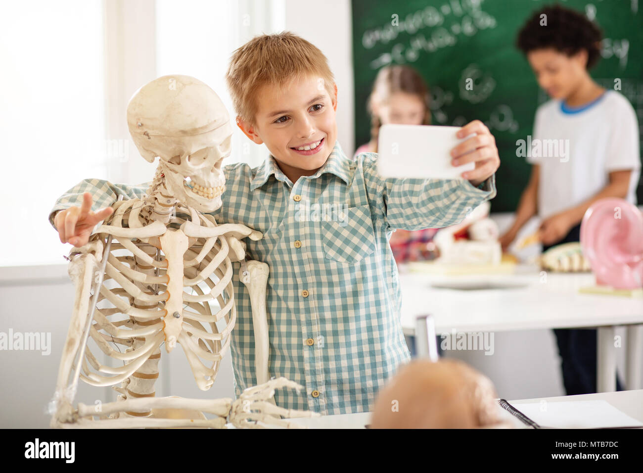 Freuen freudige Junge umarmen ein Skelett Stockfoto