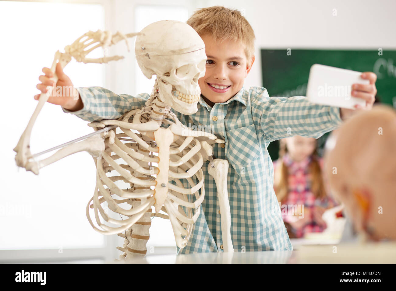 Freundliche nette Junge ein Foto mit dem Skelett Stockfoto