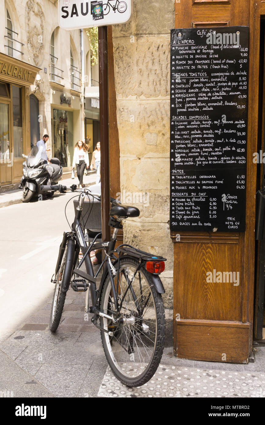 Paris Street Scene-Straße täglich Menü in einem Restaurant in Paris Saint Germain und ein Fahrrad gegen die Wand gelehnt. Stockfoto