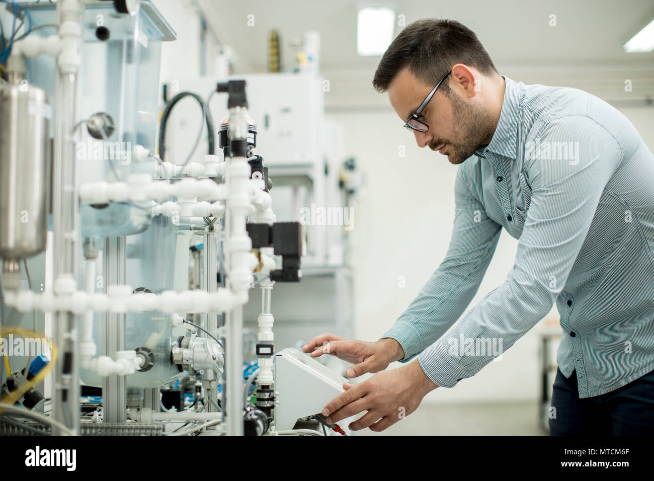 Hübscher junger Mann, der in der elektronischen Werkstatt Stockfoto