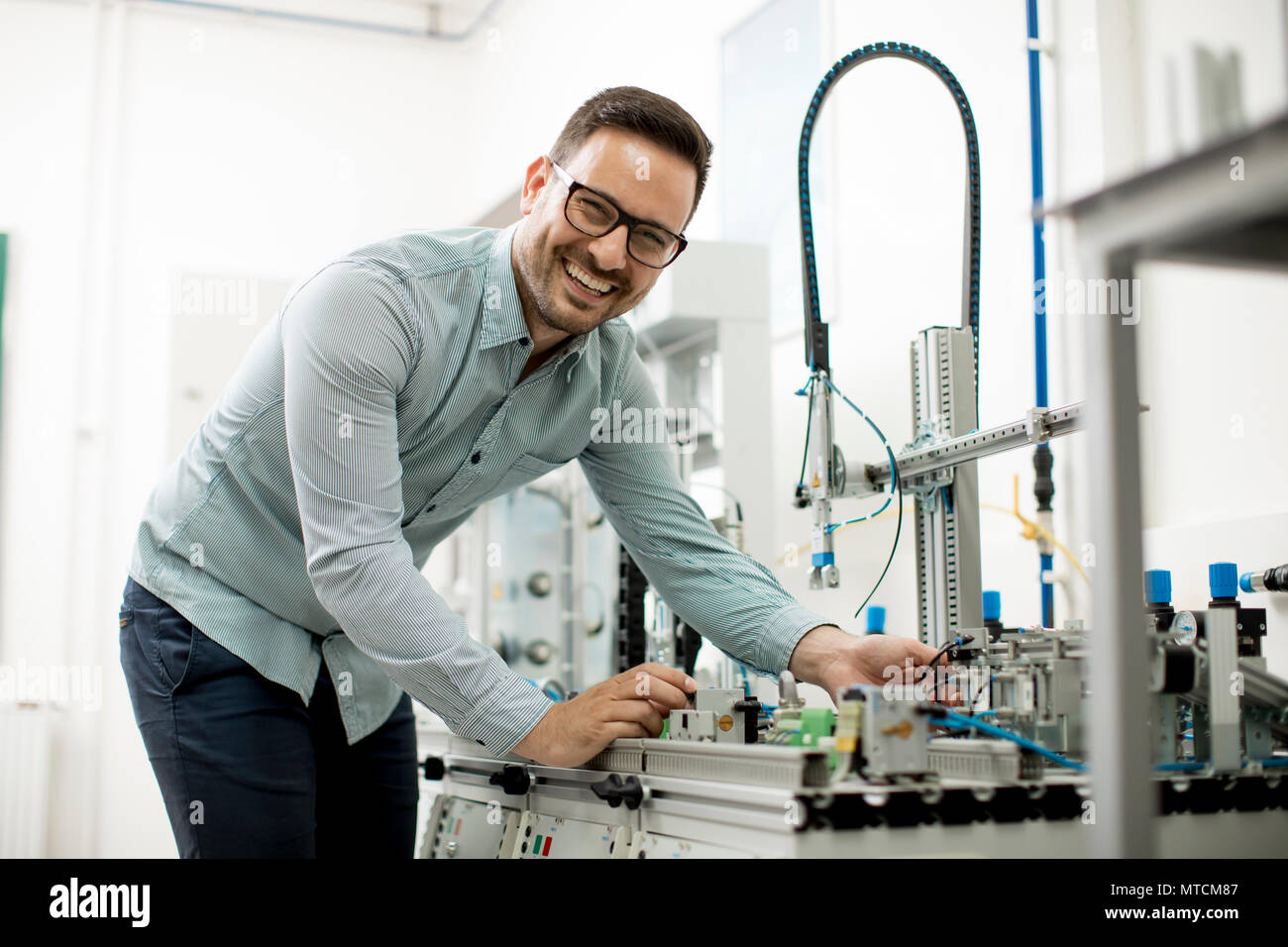 Hübscher junger Mann, der in der elektronischen Werkstatt Stockfoto