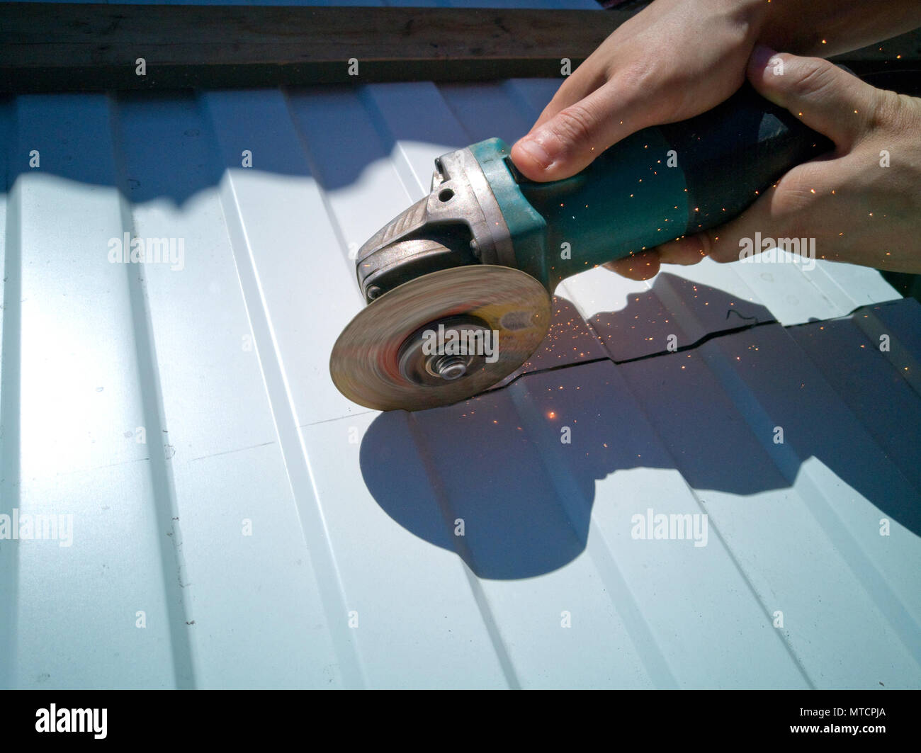 Der Master schneidet das Blech mit einer Kreissäge. Stockfoto