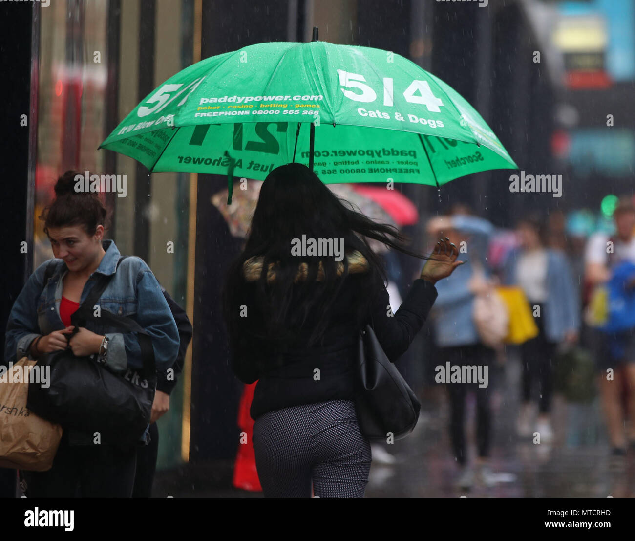 Menschen im Regen auf der Oxford Street, Londons als Meteorologen haben warnte vor der Gefahr von mehr Überschwemmungen, Unterbrechungen und Stromausfälle mit Gewittern an zu rumpeln. Stockfoto