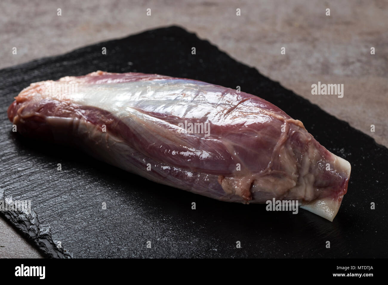 Ein frisches rohes Stück Rindfleisch auf dunklem Schiefer Stockfoto