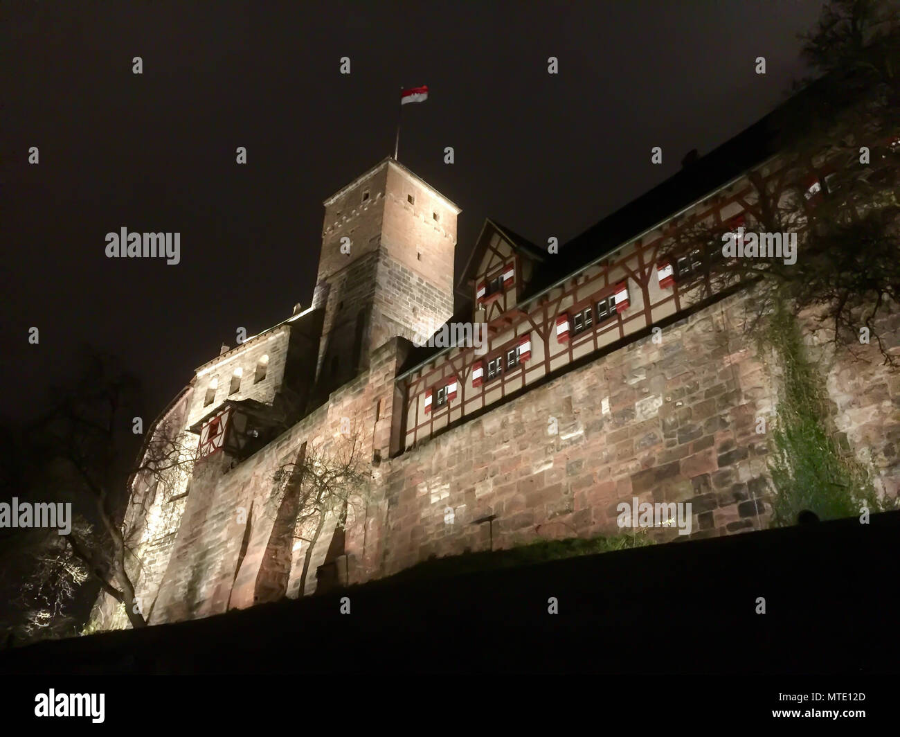 Die heidnischen Tower von Nürnberg schloss sich in den Nachthimmel mit dem Fränkischen Flagge Stockfoto