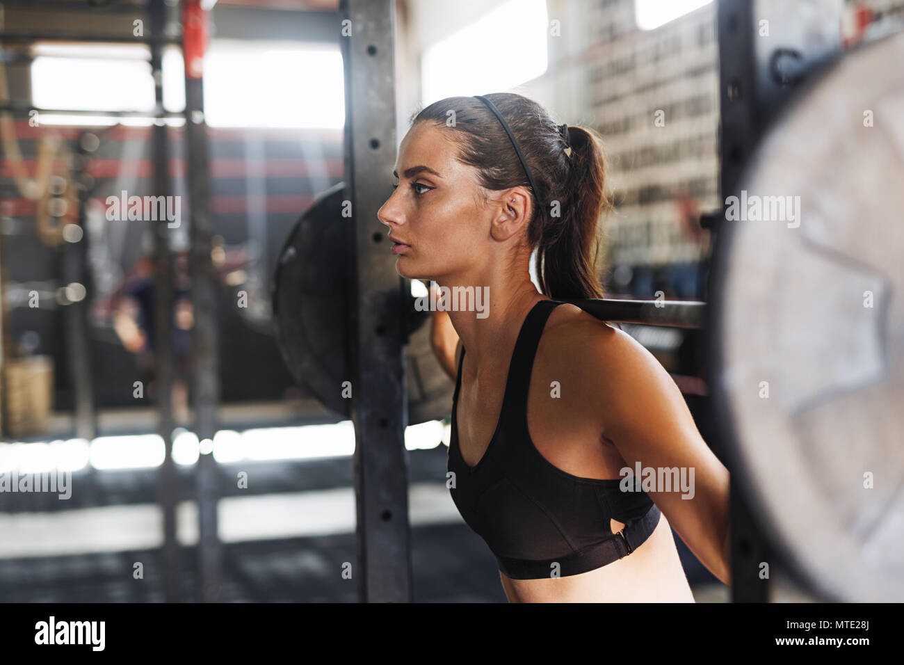 Junge sportliche Frauen arbeiten im Fitnessstudio mit schweren Gewichten Stockfoto