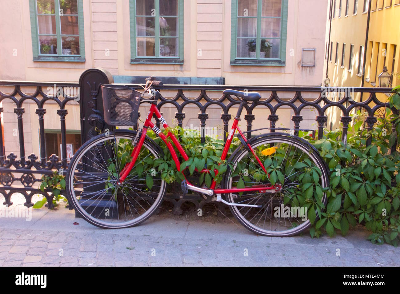 Red Bike gegen schwarze Schienen in Sodra Benickebrinken, Gamla Stan, Stockholm, Schweden schiefen Stockfoto