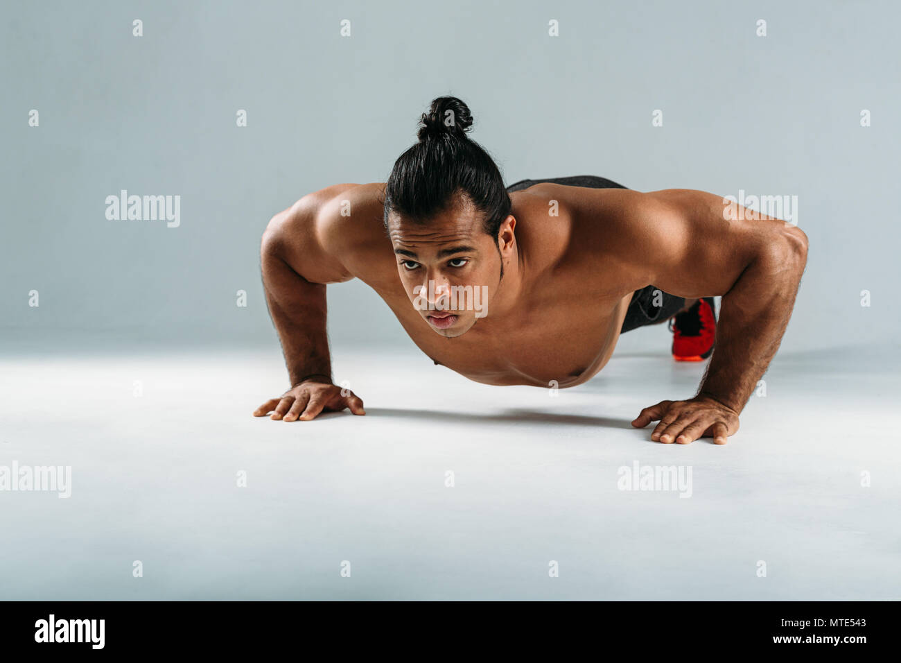 Muskulöse Mann tun Push up Übungen im Studio, Vorderansicht Stockfoto