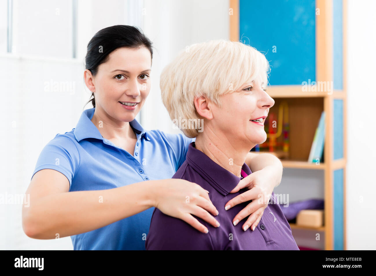 Masseurin Anwendung Nacken Massage auf ältere Frau Stockfoto
