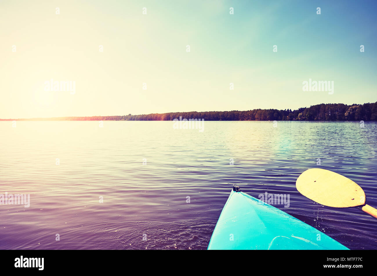 Bug eines mit dem Kajak Paddel auf einen stillen See bei Sonnenuntergang, Farbe getonte Bild, selektive konzentrieren. Stockfoto
