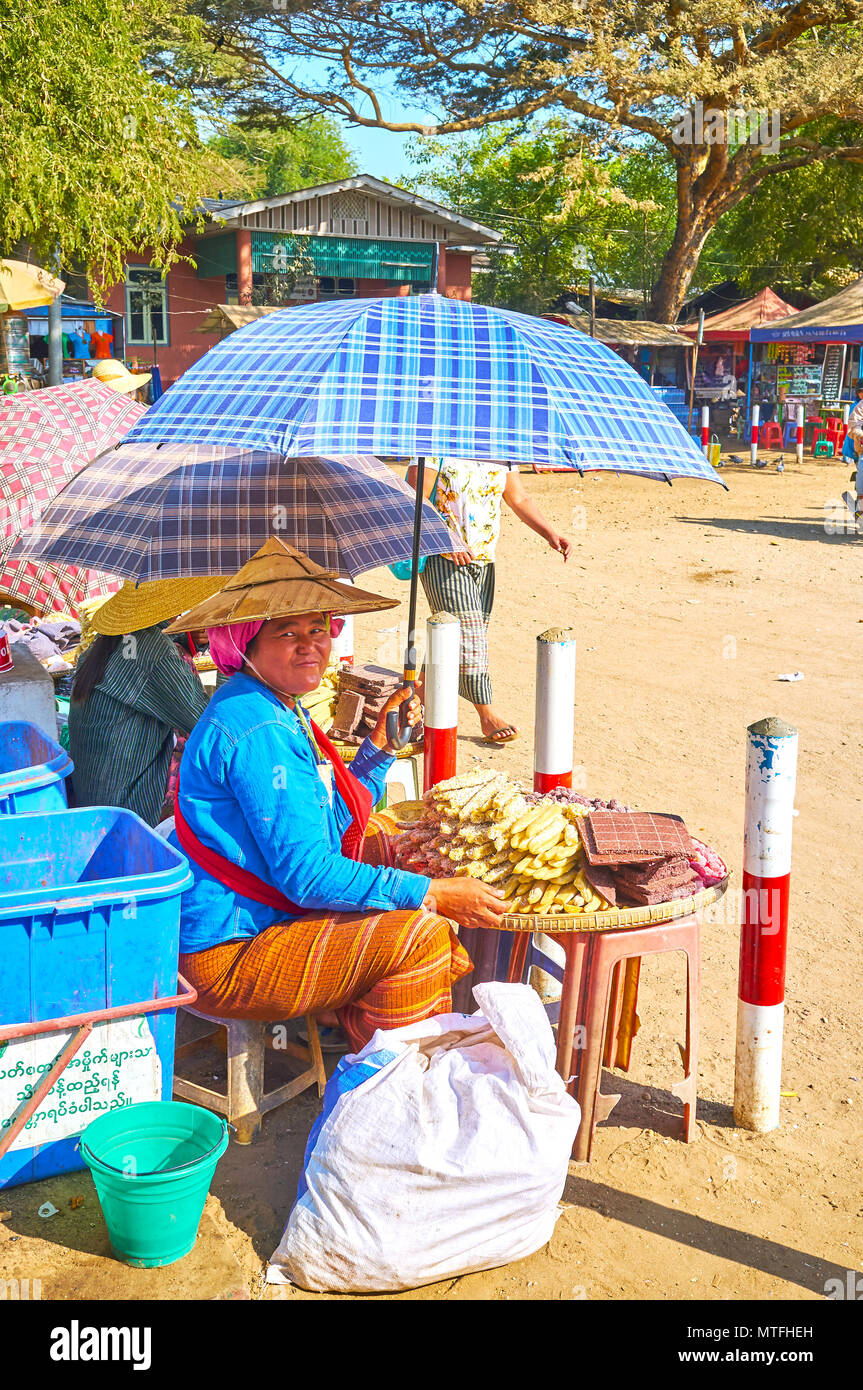 BAGAN, MYANMAR - 24. FEBRUAR 2018: Die smilimg Kaufmann verkauft Süßigkeiten aus steigen Mehl, am 24. Februar in Bagan Stockfoto