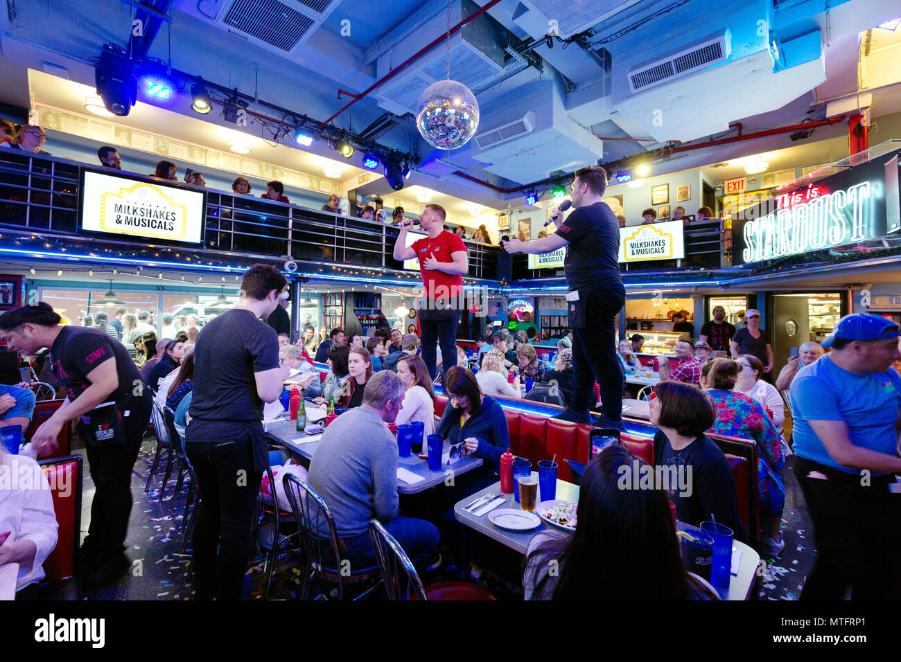 Kellner performing Songs aus Musicals in Ellens Stardust Diner Restaurant, während Diners auf, Broadway, New York City, USA Stockfoto